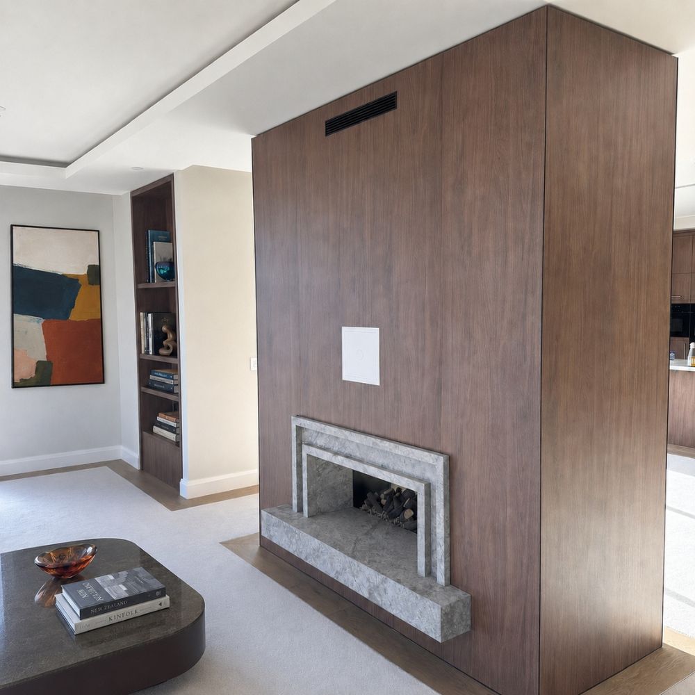 A high end residential living room with dark brown paneling joined at the corner with a Stickman power-coated black MCLN Linear exterior corner join profile